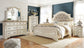 Realyn  Upholstered Panel Bed With Mirrored Dresser, Chest And 2 Nightstands